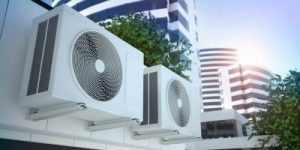 Two air conditioners outside of some high-rise buildings