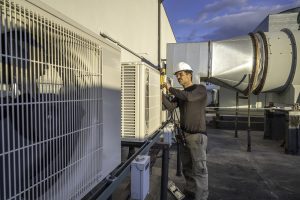 Hvac Technician Servicing Commercial Air Conditioning Equipment